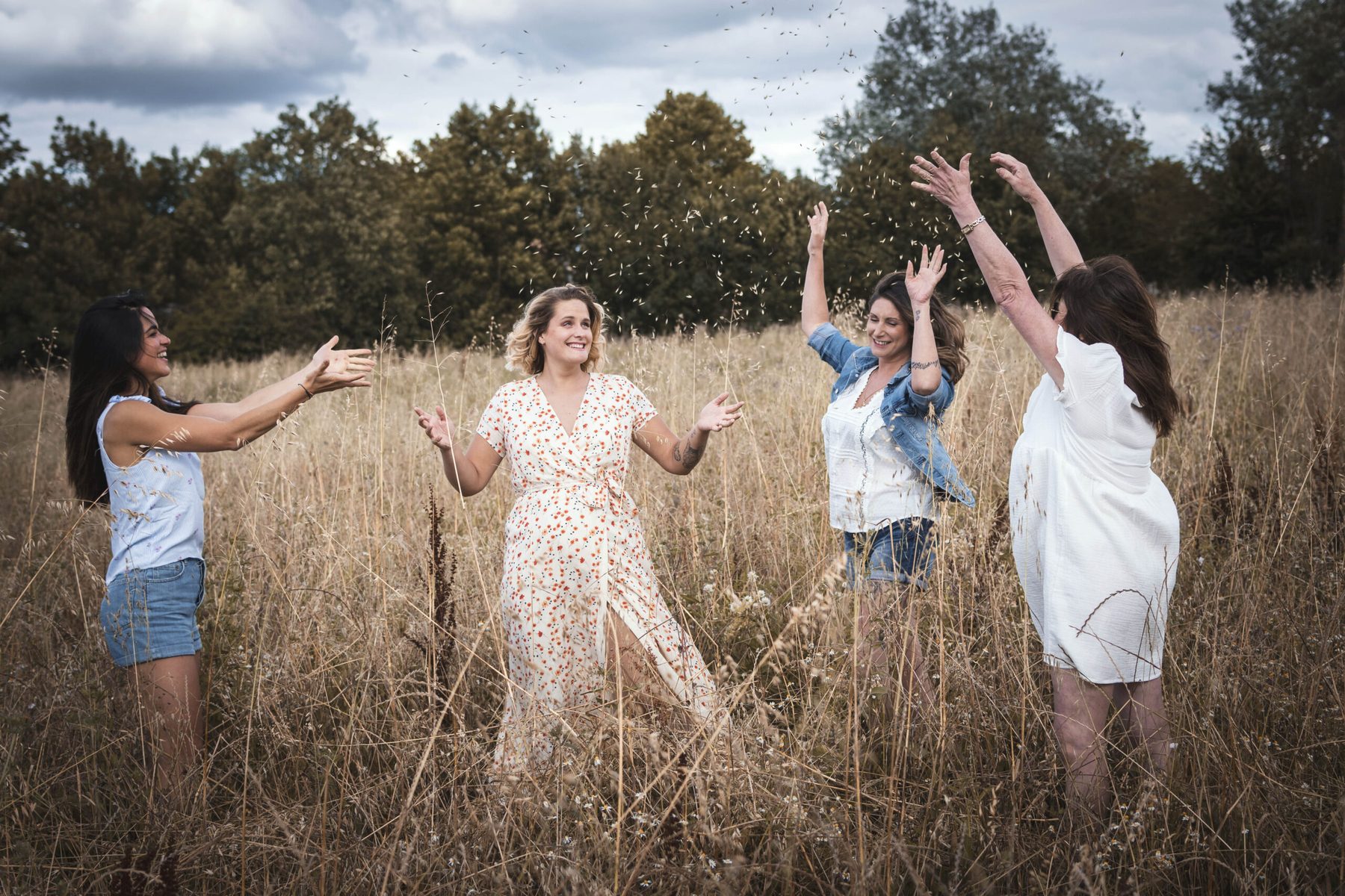 Famille joyeuse en extérieur, bras levés, lumière douce dans le Tarn