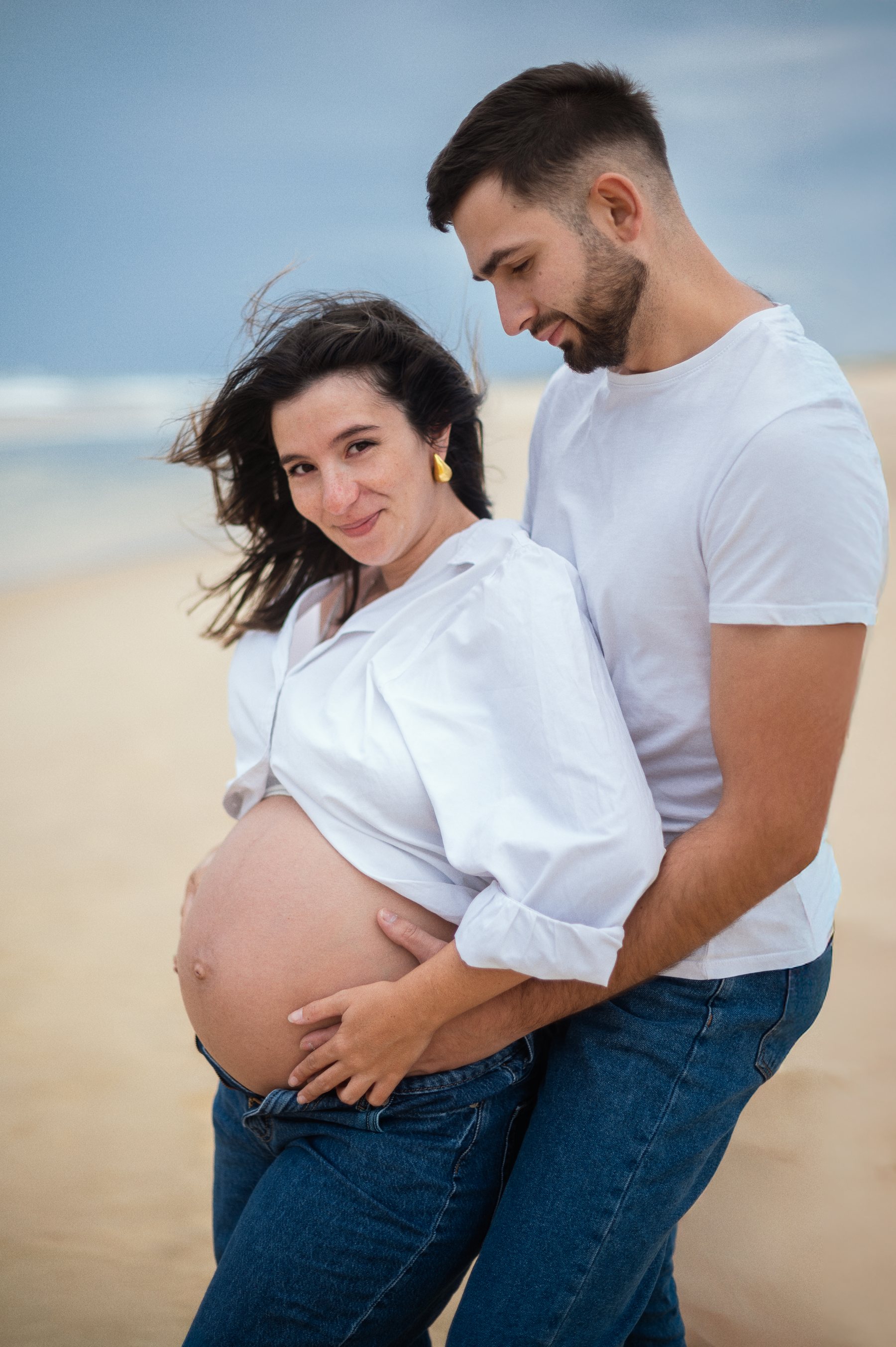 Future maman et son compagnon sur la plage