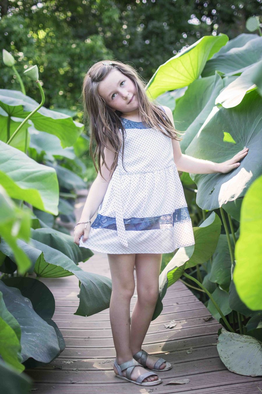 Petite fille en robe blanche dans la végétation